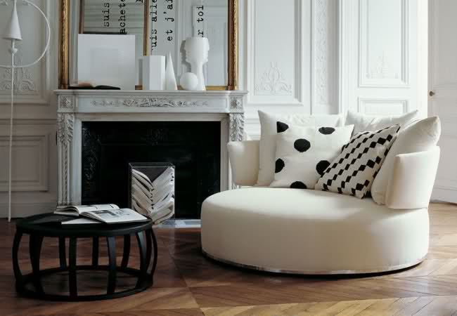 Круглый диван в интерьере гостиной с камином