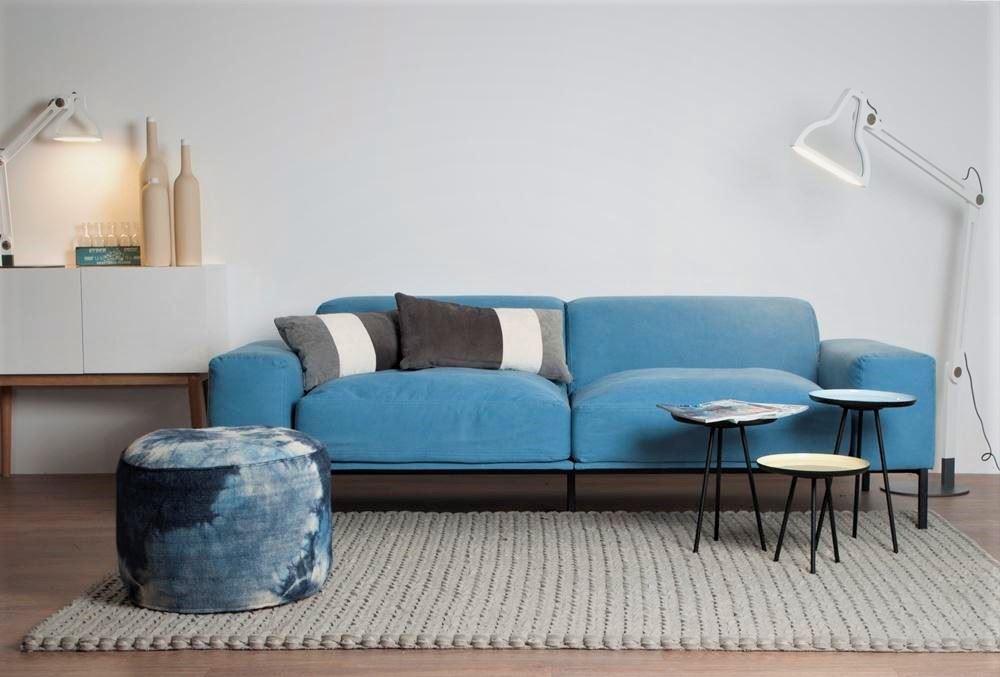 Мягкий голубой диван у стены