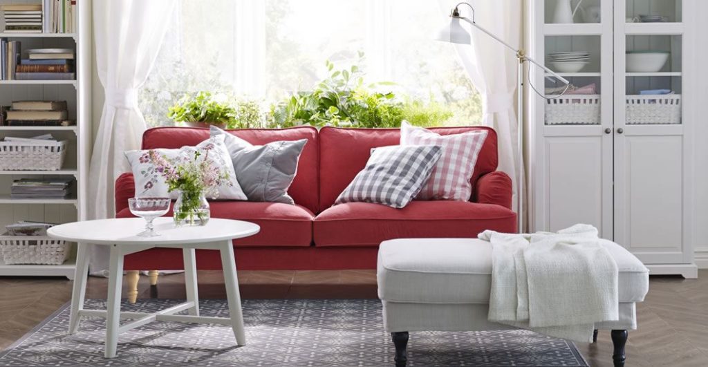 Небольшой прямой красный диван в светлой комнате