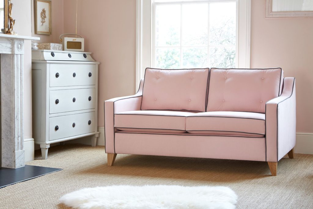 Розовый диван в комнате со стенами розового цвета