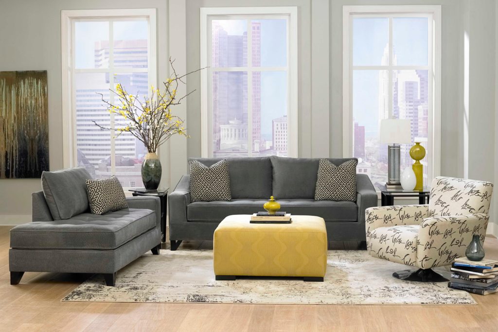 Серый диван и кушетка в интерьере со светлым креслом и желтым пуфиком