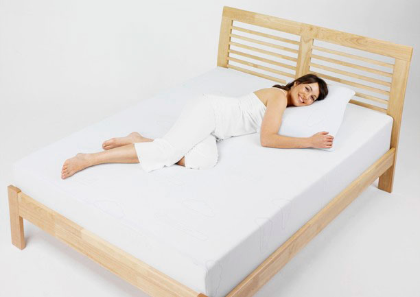 Женщина лежит на кровати с анатомическим матрасом