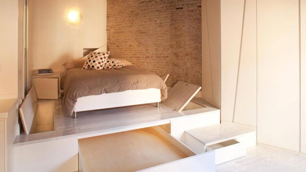 Фото кровати расположенной на подиуме оснащенном встроенными ящиками