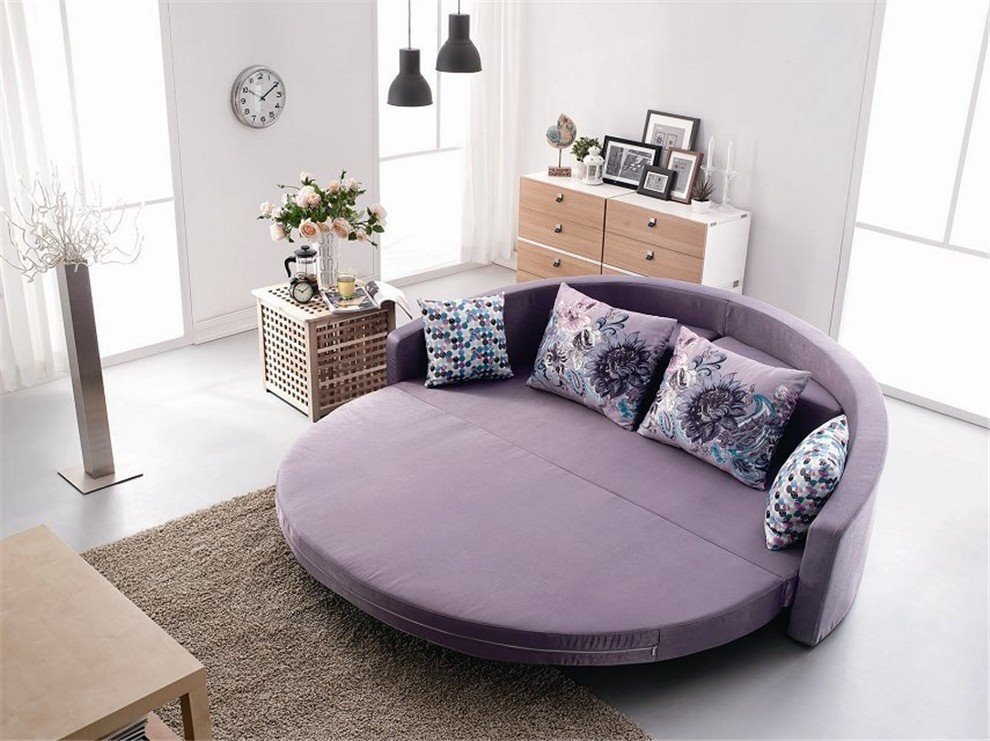 Раскладной круглый диван-кровать со спальным местом в интерьере спальной комнаты