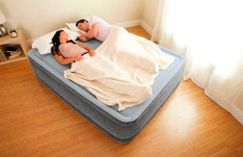 Семейная пара спит на надувной кровати