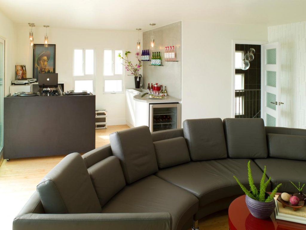 Большой кожаный диван модульного типа в интерьере кухни-гостиной