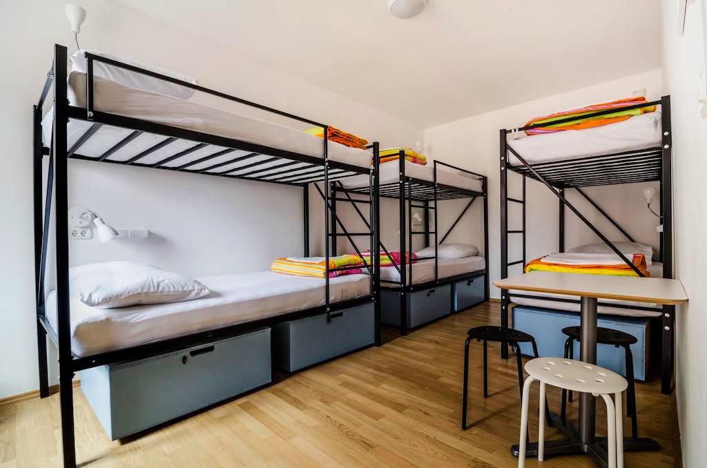 Металлические двухъярусные кровати для взрослых в интерьере комнаты