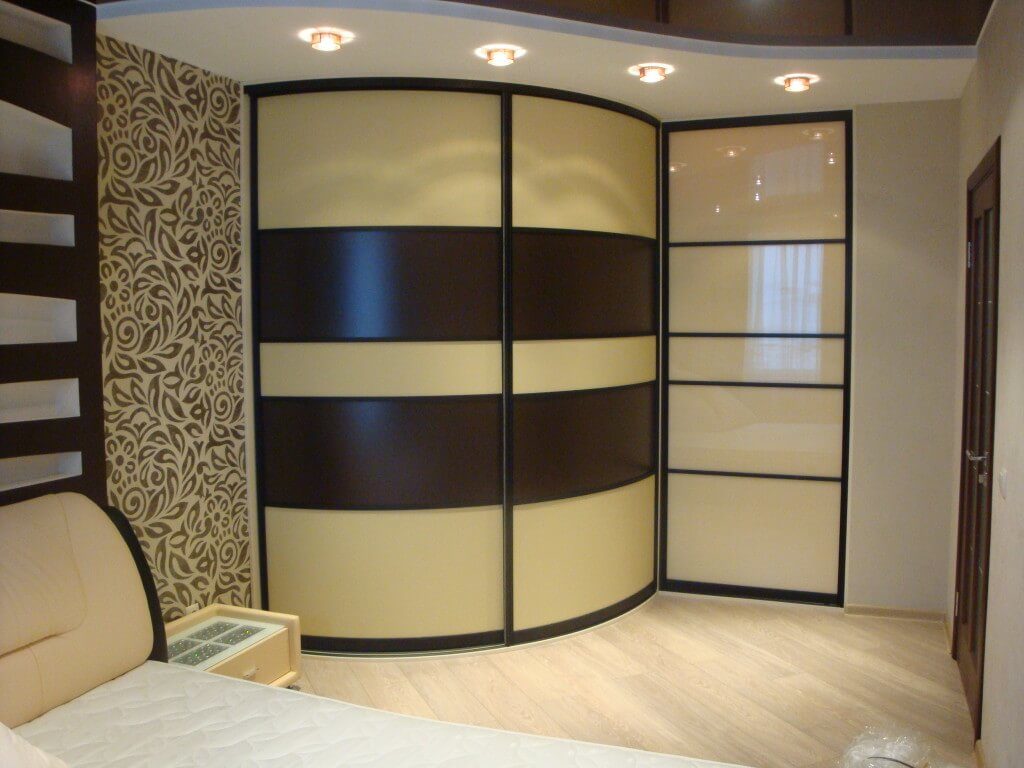 Угловой шкаф купе с радиусным фасадом в интерьере спальной